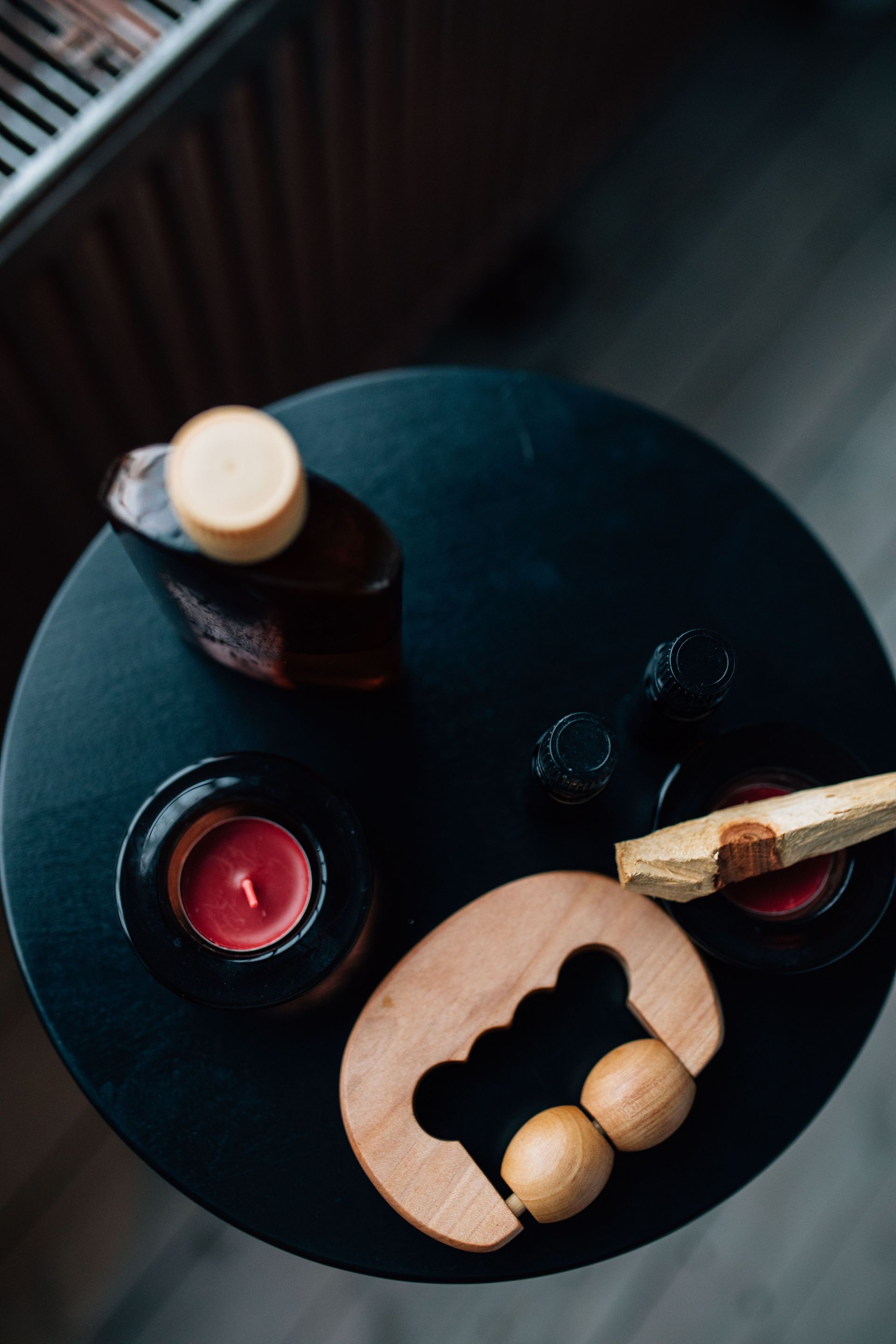 Top view of aromatherapy essentials including candles, massage tools, and essential oils on a table.
